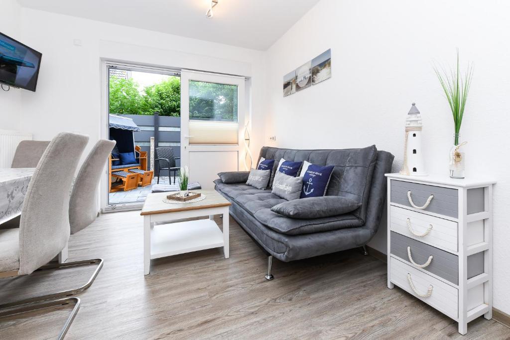 a living room with a couch and a table at Ferienwohnungen Haus Boje "Scholle" in Neuharlingersiel