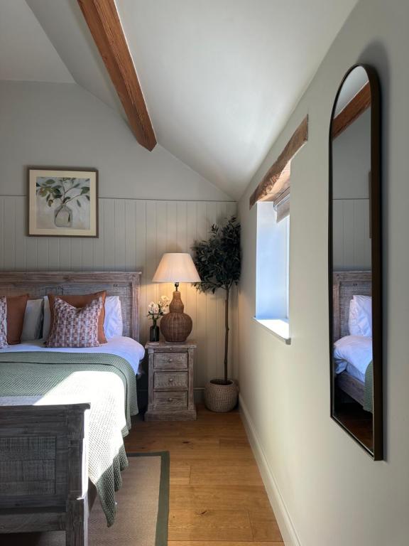 a bedroom with a bed and a mirror at The Red Lion Inn Alnmouth in Alnmouth
