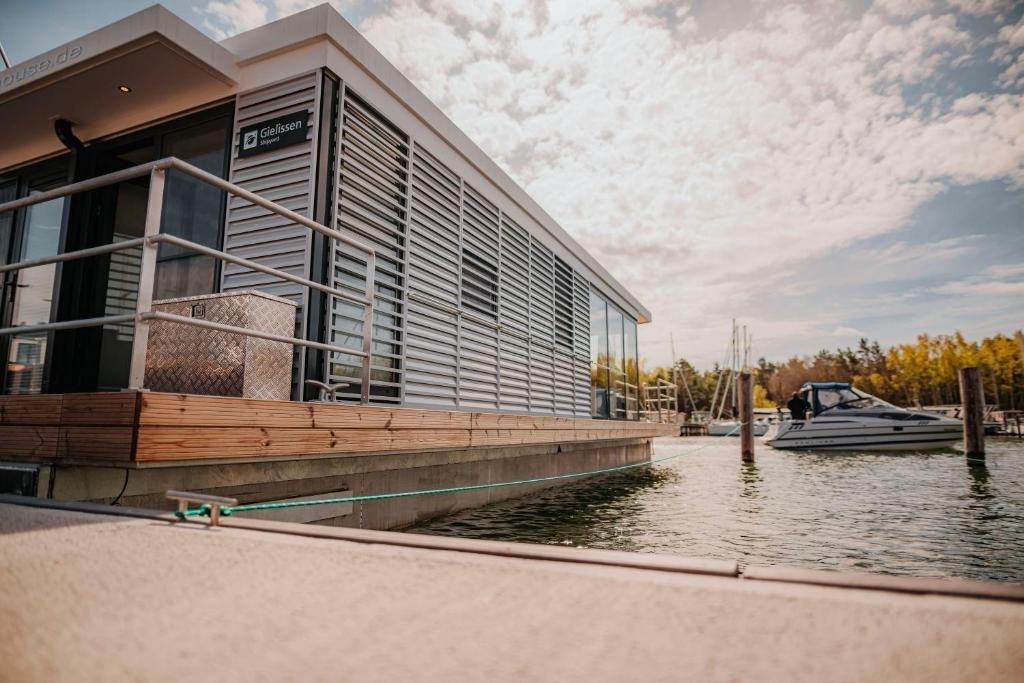 een groot gebouw met een boot in het water bij Hausboot freiZeit - LP4 in Peenemünde