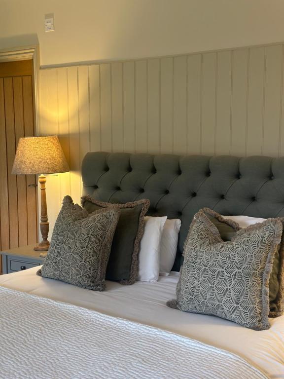 a bedroom with a large bed with a large headboard at The Red Lion Inn Alnmouth in Alnmouth