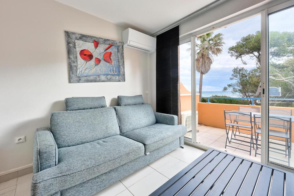 d'un salon avec un canapé et un balcon. dans l'établissement Résidence La Pinède - maeva Home - Appartement 2 pièces 4 personnes vue Mer - Sélection MAE-4181, à Hyères