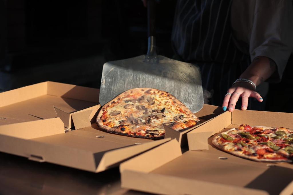 two pizzas are sitting in boxes on a table at The Red Lion Inn Alnmouth in Alnmouth
