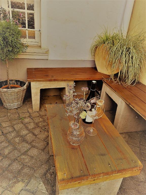 a wooden table with two glasses and a vase of flowers at Ferienwohnung Villa Wolke in Sankt Wendel