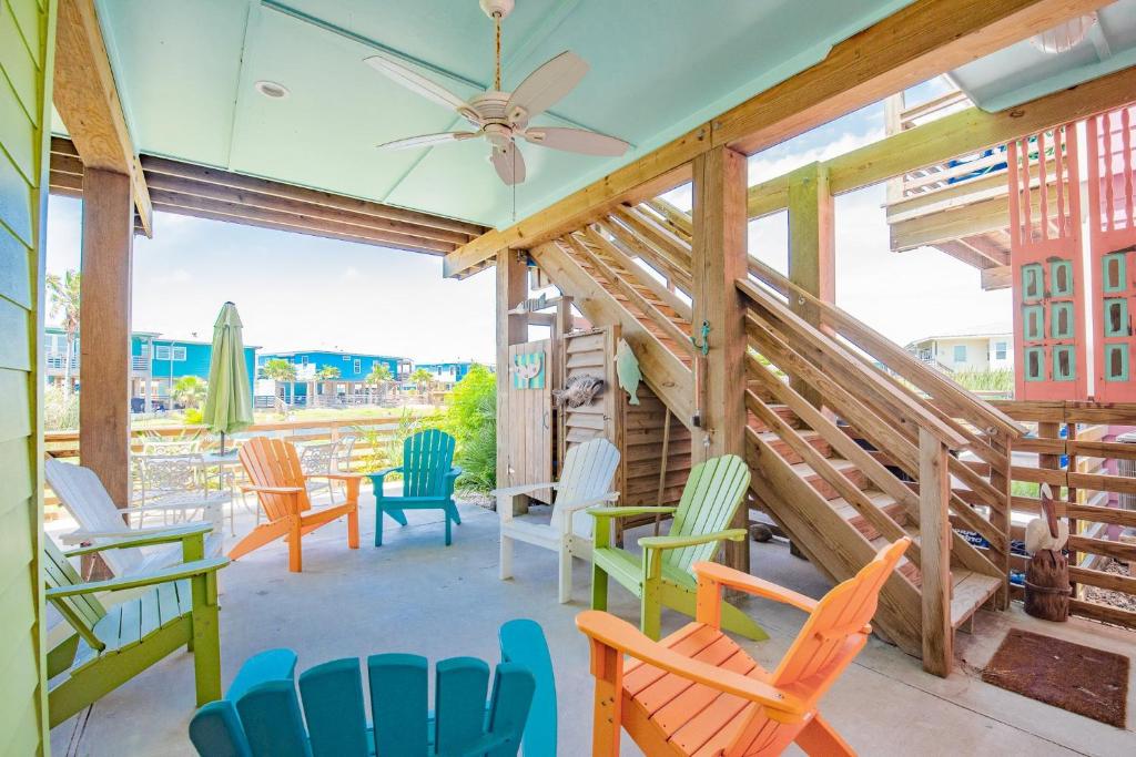 - une terrasse couverte avec des chaises colorées et un ventilateur de plafond dans l'établissement Mermaid Cove PA - Beach Gear Credit Included, à Fresno