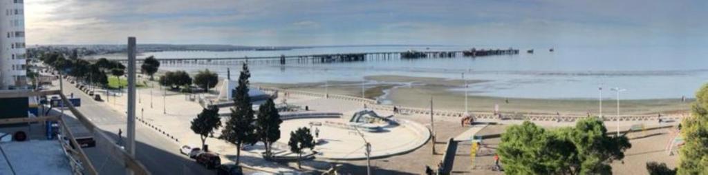 a park next to a beach with a pier at Puerto Madryn Temporarios- Frente al Mar in Puerto Madryn