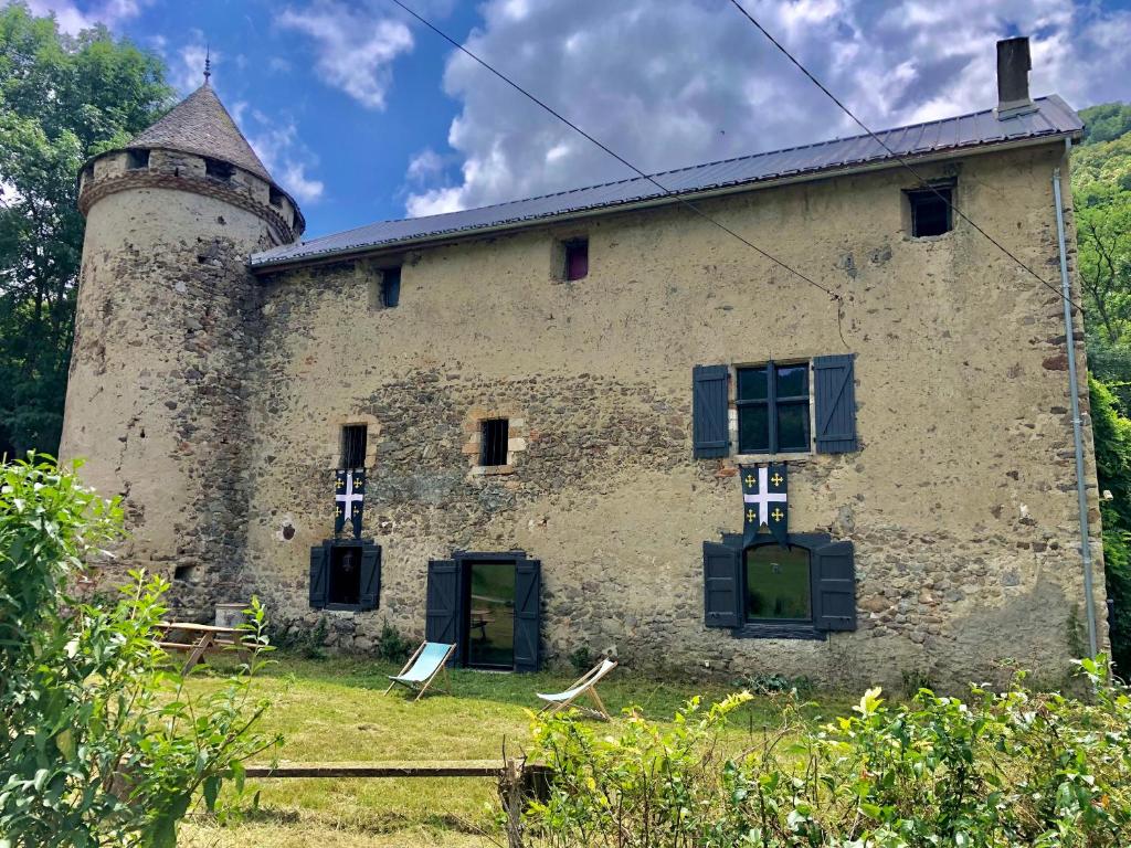 un ancien bâtiment en pierre avec une tour dans l'établissement Fraîcheur garantie château perché avec rivière privée en pleine nature, à Cazenave-Serre-et-Allens