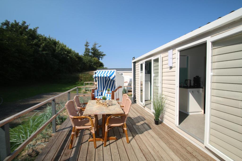 a wooden deck with a table and chairs on it at Ostseeferienpark Walkyrien - Bootsmann 02 in Schashagen