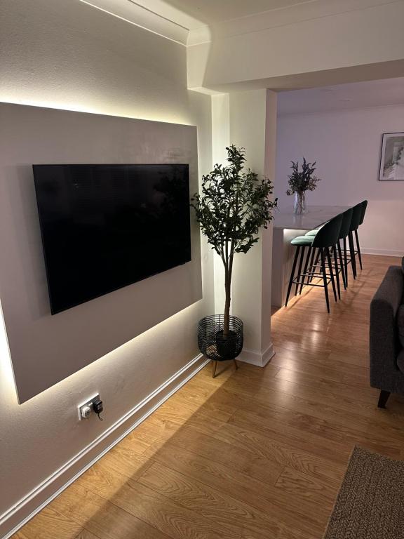 un soggiorno con una TV a schermo piatto su una parete di Lux 2 Bedroom Ground Floor Apartment a Edimburgo