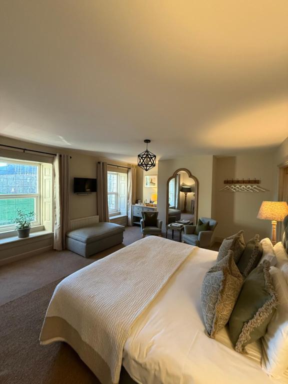 a large bedroom with a large bed and a living room at The Red Lion Inn Alnmouth in Alnmouth