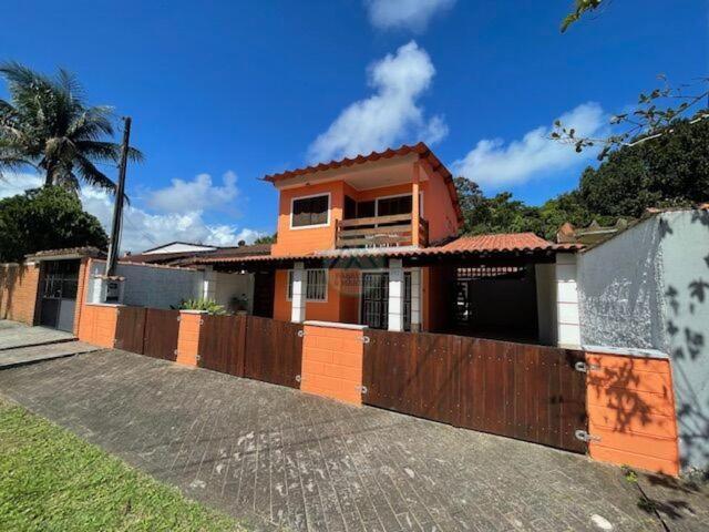 a house with a wooden fence in front of it at CASA DUPLEX Jardim São Lourenço in Bertioga