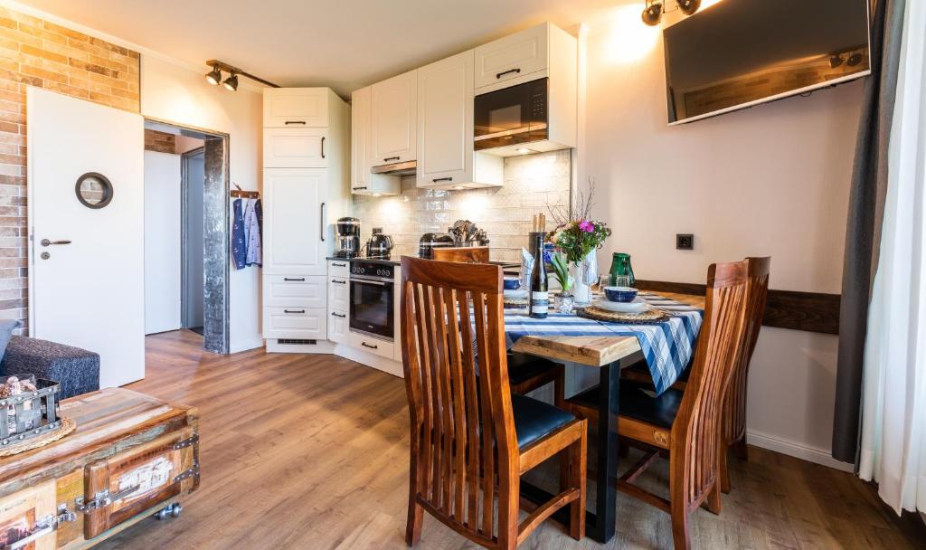 a kitchen and dining room with a table and chairs at Terrassen-Fewo "Ankerplatz" direkt am Ostseestrand inkl Schwimmbad in Kronsgaard