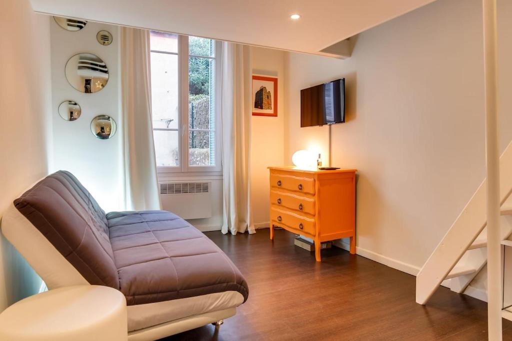 un salon avec un canapé et une télévision dans l'établissement Cannes centre Cosy appartement avec mezzanine, à Cannes