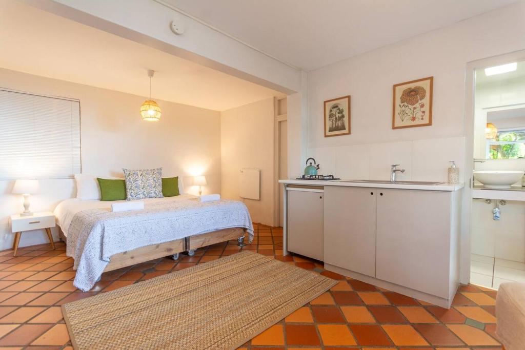 ein Schlafzimmer mit einem Bett und einem Waschbecken darin in der Unterkunft St James Garden Cottage in St James