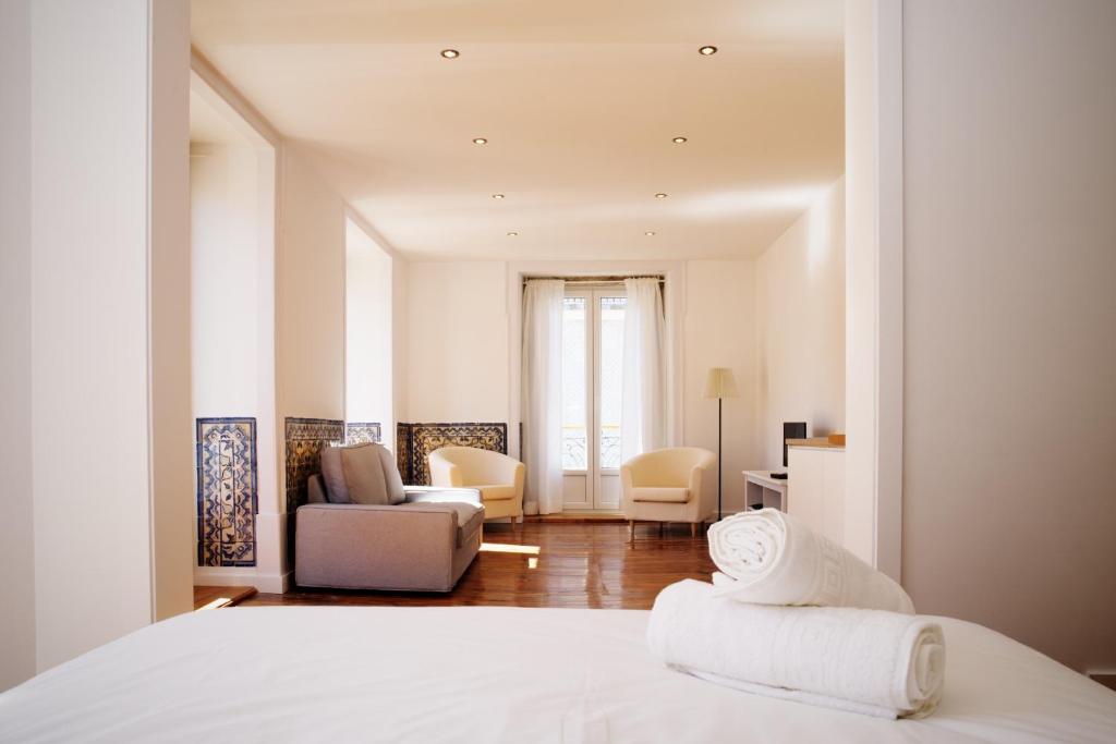 里斯本的住宿－GS希亞多精品一室公寓及套房，一间卧室设有一张床和一间客厅。