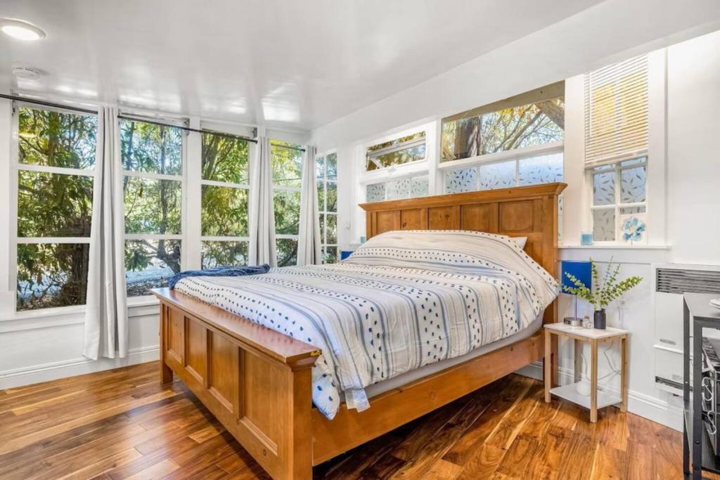 sypialnia z dużym łóżkiem i oknami w obiekcie Jennifers Room - Pet Friendly w mieście Summerland
