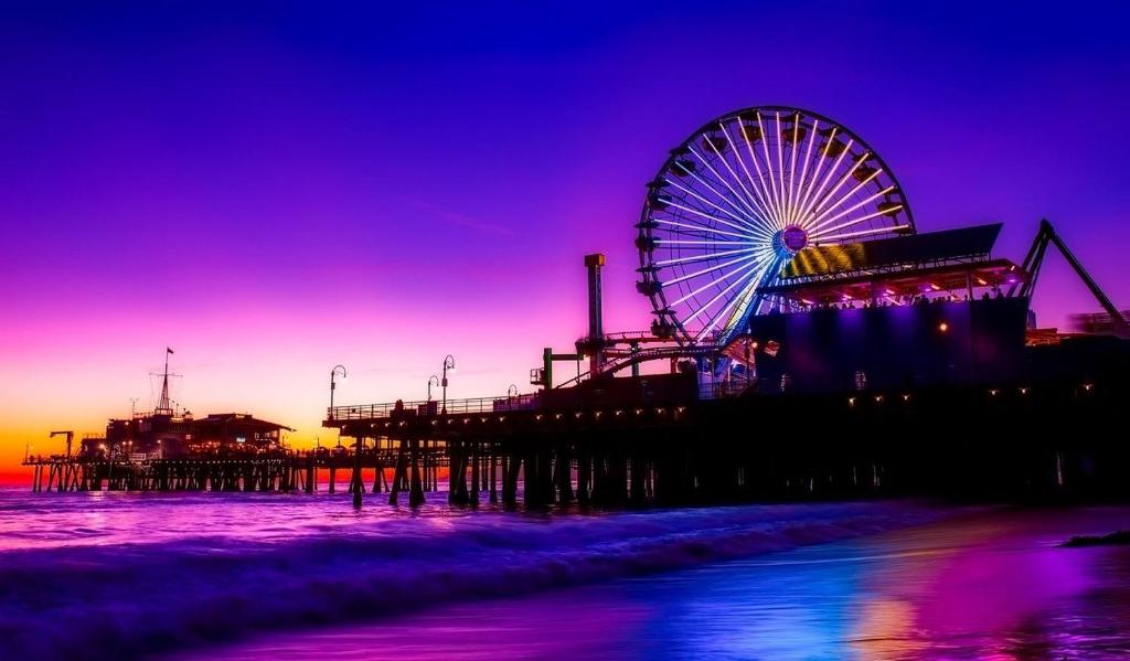 a ferris wheel on the beach next to a pier at Santa Monica Bright Studio with stunning view in Los Angeles
