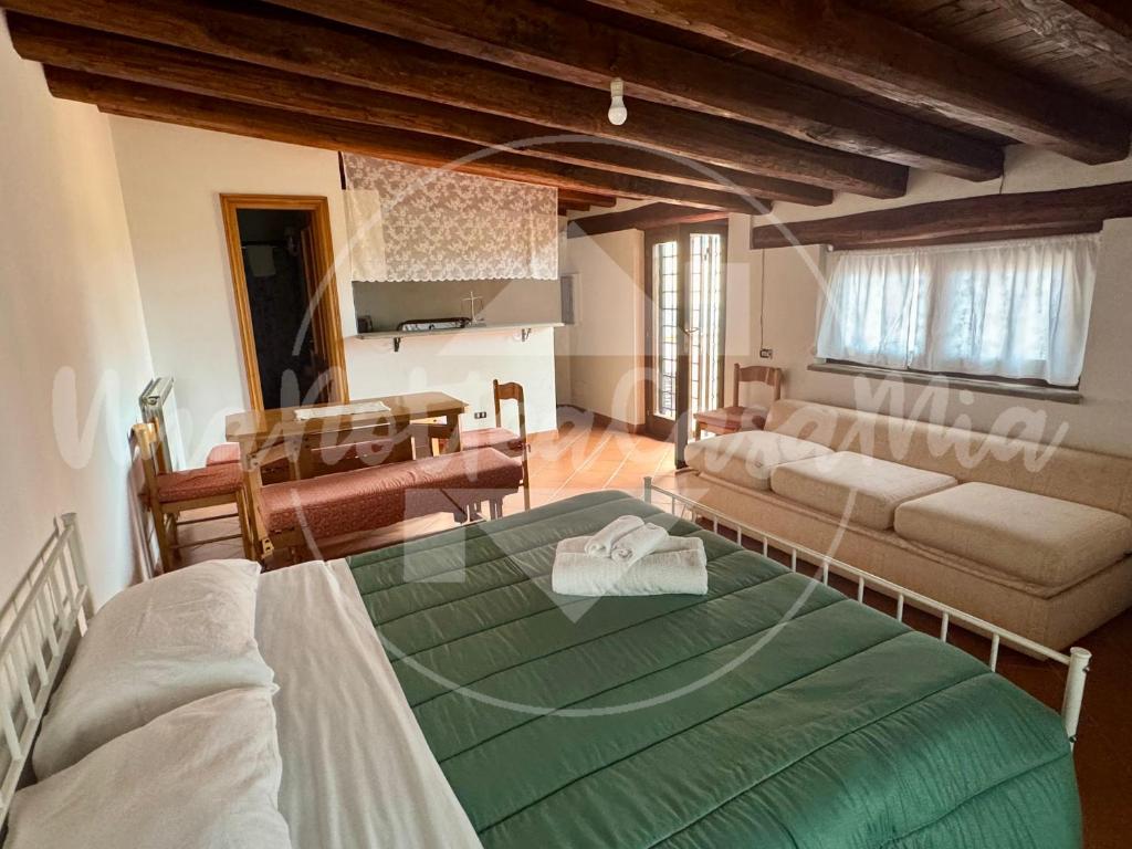 a living room with a large green bed and a couch at Villa Federica "UnaNotteaCasaMia" in Sacrofano