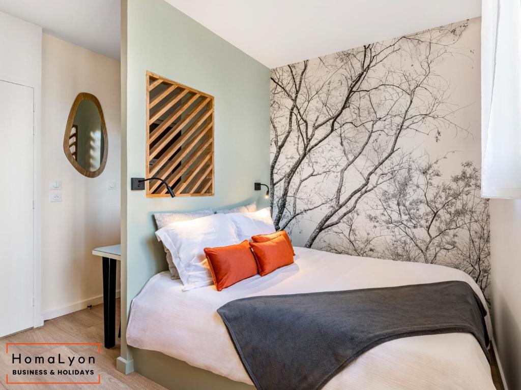 une chambre avec un grand lit avec des oreillers orange dans l'établissement Studios Part-Dieu Gare - HomaLyon, à Lyon
