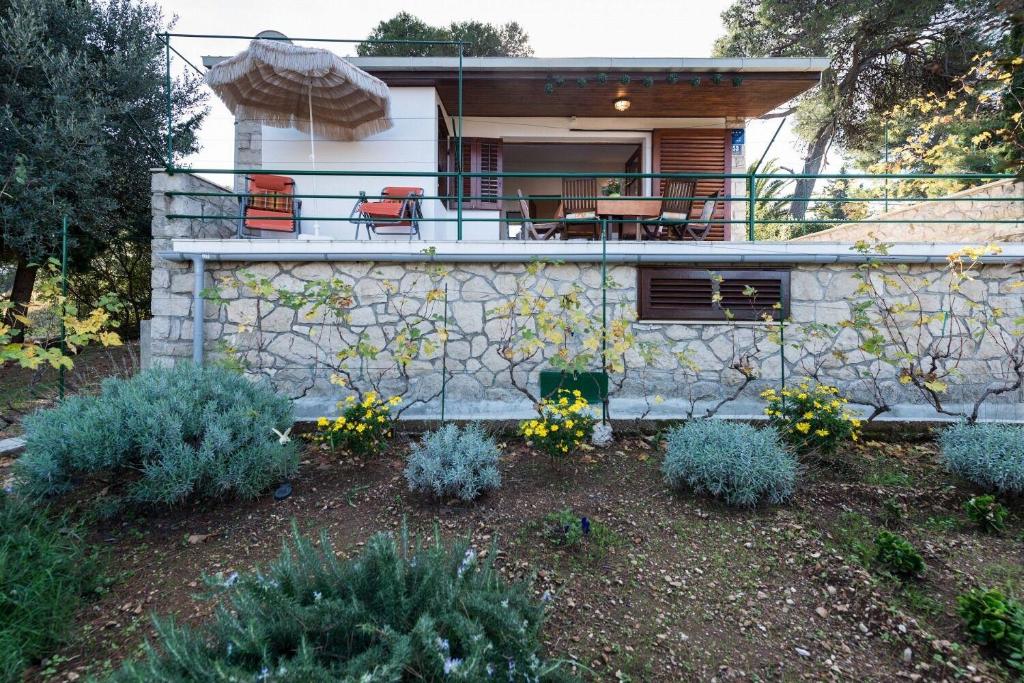 a house with a balcony with chairs and flowers at House Viki in Postira