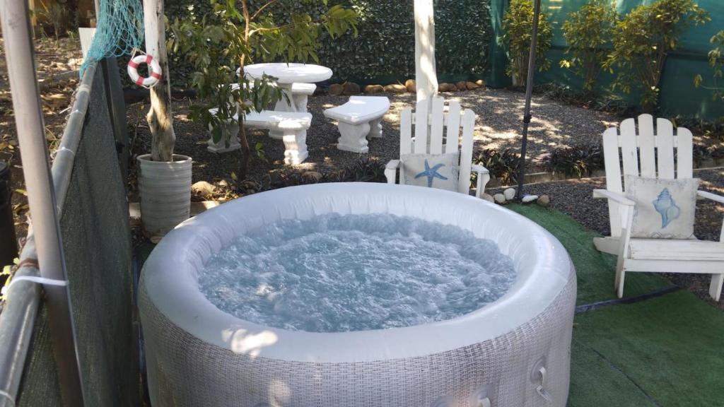 a bath tub with two chairs in a yard at Villa jr 1 Private Jacuzzi near peñon guacalillo in Tivives