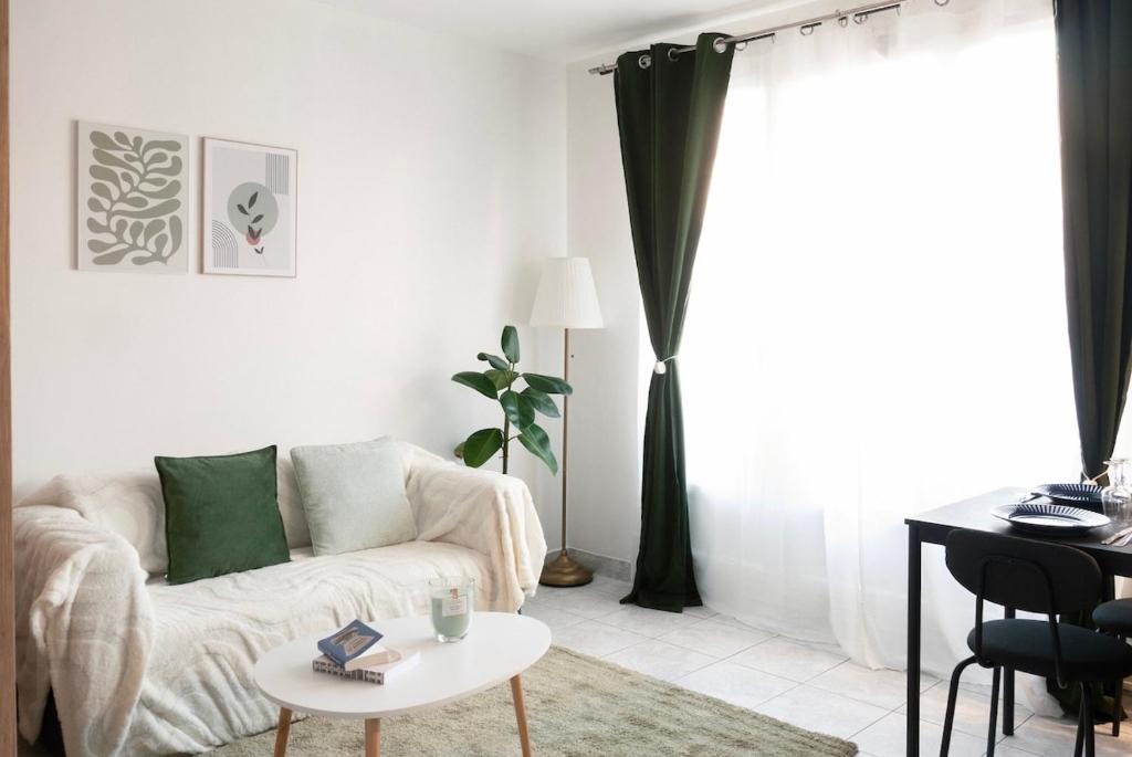 un salon avec un canapé et une table dans l'établissement L'Émeraude Porte de Paris - Aéroport CDG, Stade de France, Metro 12, à Aubervilliers