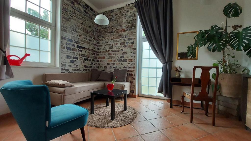 Una sala de estar con un sofá y una pared de ladrillos. en Leipzig Ferienwohnung in ruhiger Lage, en Leipzig