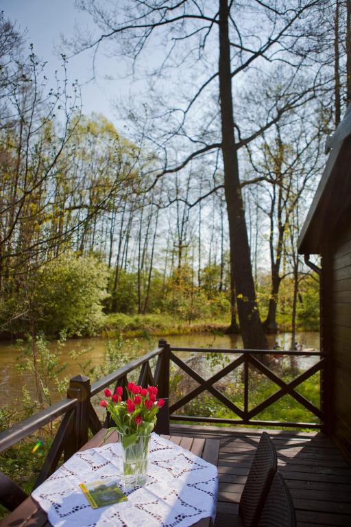 a table with a vase of flowers on a deck at Ferienhaus 4 Prs in Kaupen