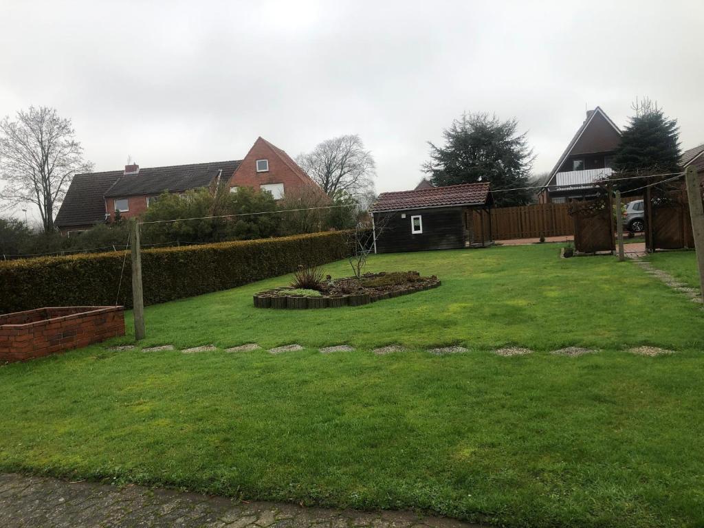 a backyard with a yard with green grass at Ferienhaus Ostfriesland in Berumbur