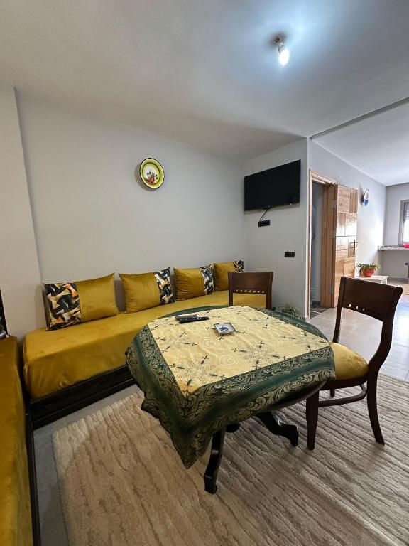 a living room with a yellow couch and a table at Sand house in Oualidia