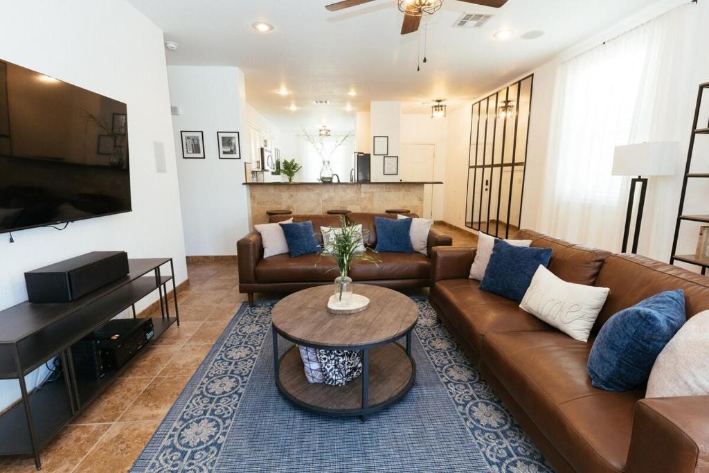 una sala de estar con un sofá y una mesa en Industrial Desert Oasis 3 BDR Home, en Horizon City