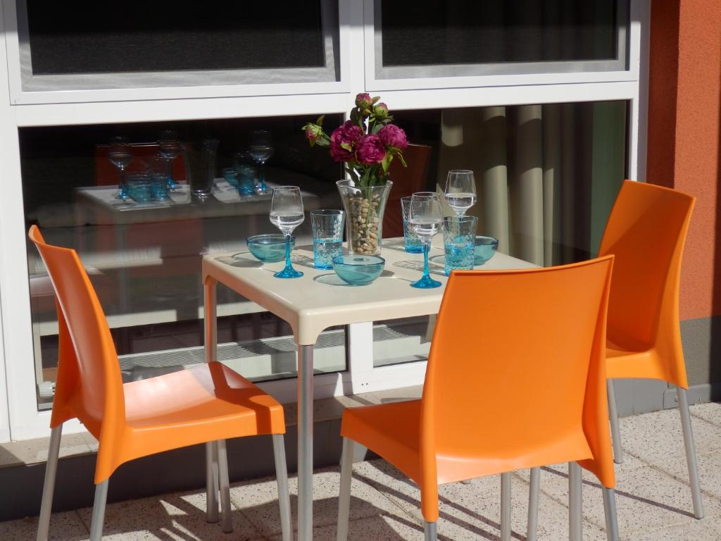 uma mesa branca com cadeiras e um vaso de flores em Ubytování U lázní Aurora em Třeboň
