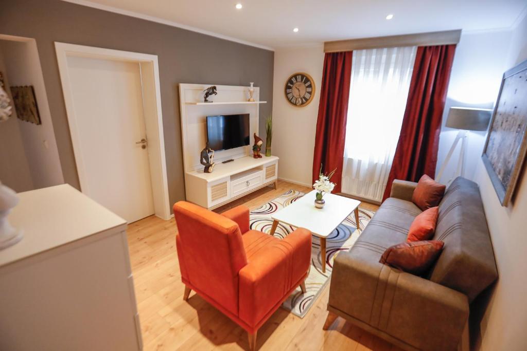 a living room with a couch and chairs and a television at Turis Ferienwohnung 65-3 in Triberg