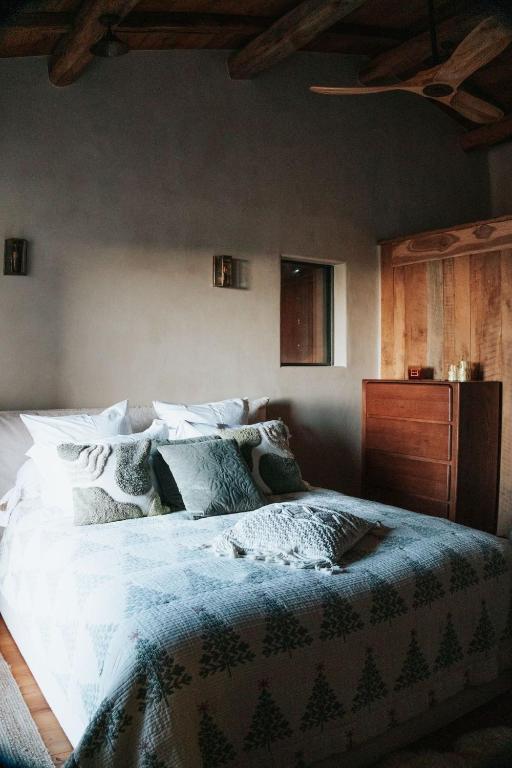 une chambre avec un grand lit avec des draps et des oreillers blancs dans l'établissement Demeure moresca, à Pietrosella
