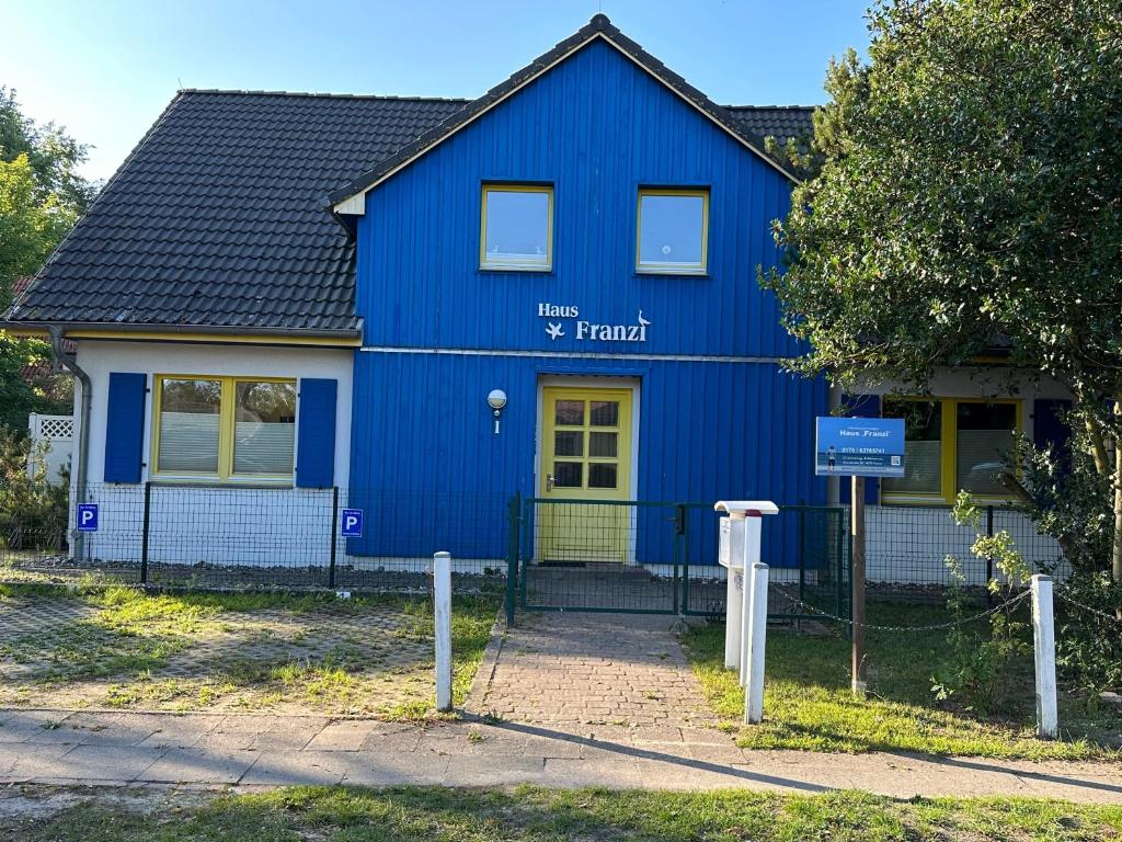 ein blaues Haus mit einem Schild auf der Vorderseite in der Unterkunft Franzi 3 in Prerow
