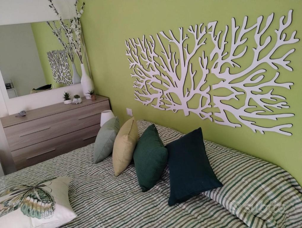 a bedroom with a bed with a tree mural on the wall at Appartamento Mare Verde Bambù in Martinsicuro