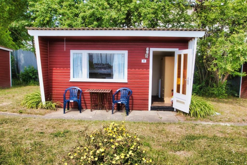 two chairs and a table in front of a red shed at Finnenhaus 4 in Lübeck