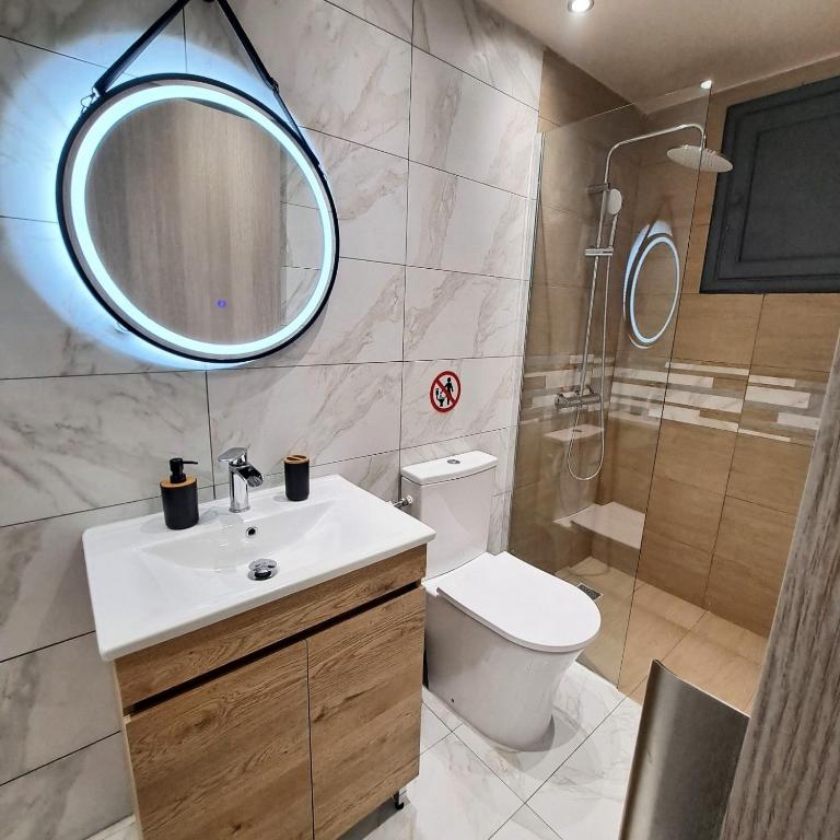 a bathroom with a toilet and a sink and a mirror at Central Piraeus port apartment in Piraeus