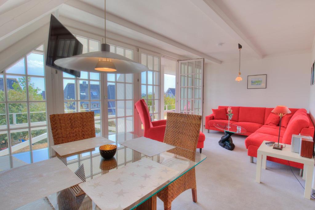 a living room with a red couch and a table at Abaco 3N in Wenningstedt