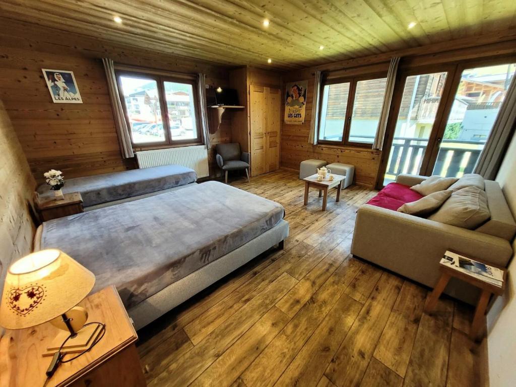 une chambre avec un grand lit et un canapé dans l'établissement Résidence Beau Sejour - Appartement confortable, idéal pour des vacances en famille MAE-5231, aux Gets