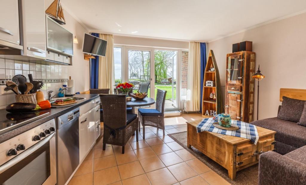 a kitchen and living room with a couch and a table at 4 Sterne-Terrassen-Fewo "Heimathaven" direkt am Ostseestrand inkl Schwimmbad in Kronsgaard