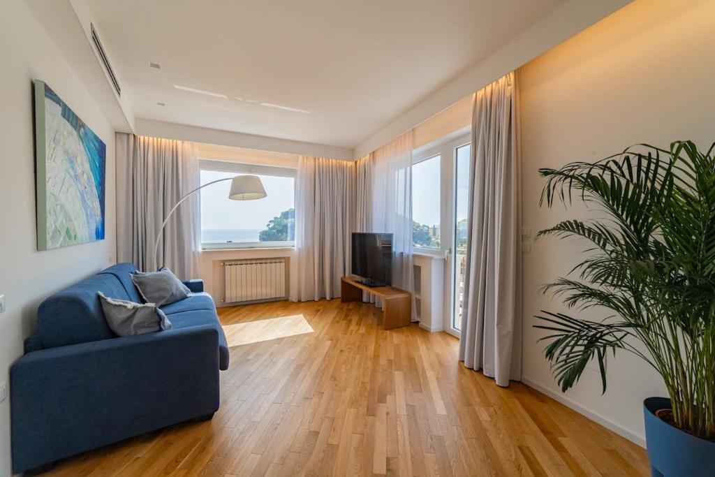 a living room with a blue couch and a tv at Appartamento al Mare in Taormina
