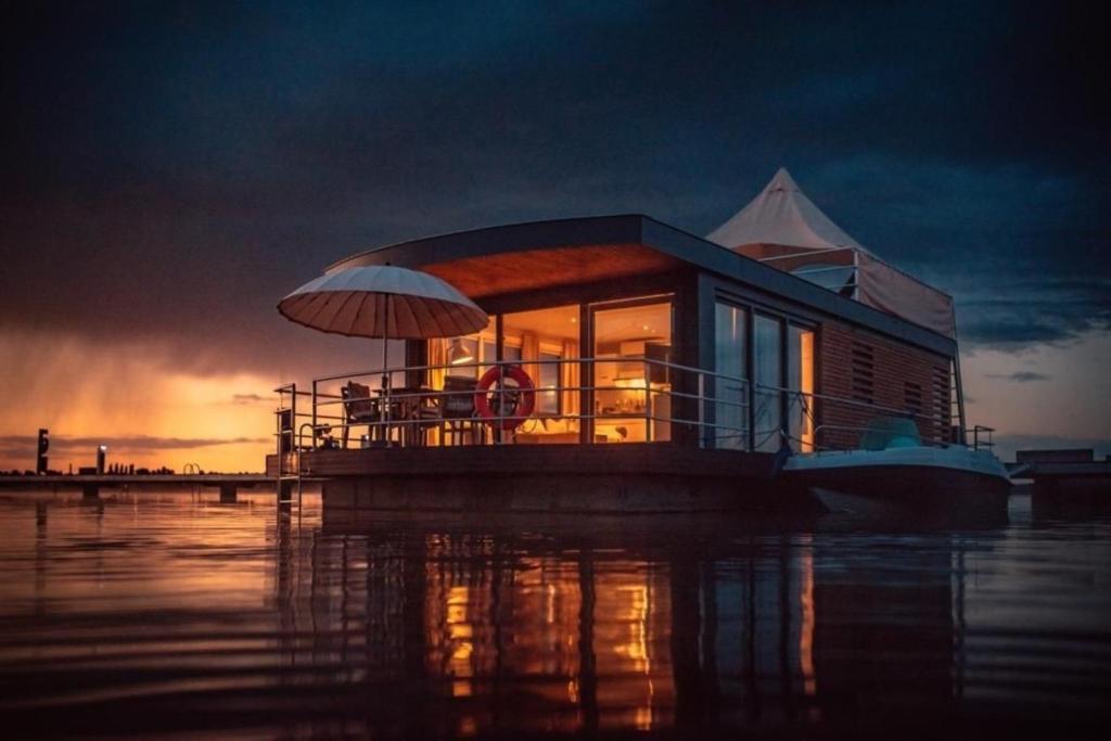 a small house on a boat in the water at Hausboot Bahama Mama in Klitten