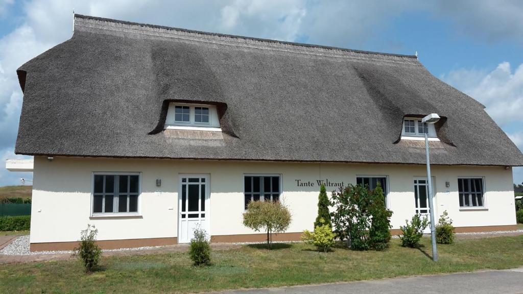 a white house with a thatched roof at Häuschen "Tante Waltraut" in Garz-Usedom