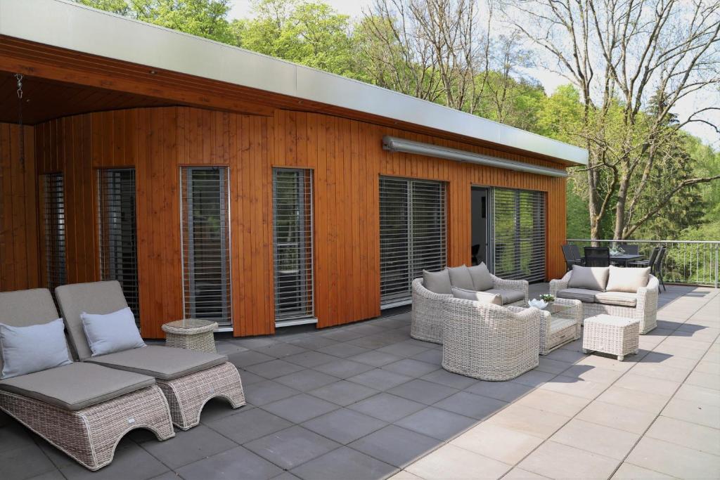 a patio with wicker chairs and tables at Villa Grün, Loft- Wohnung 09 in Tabarz
