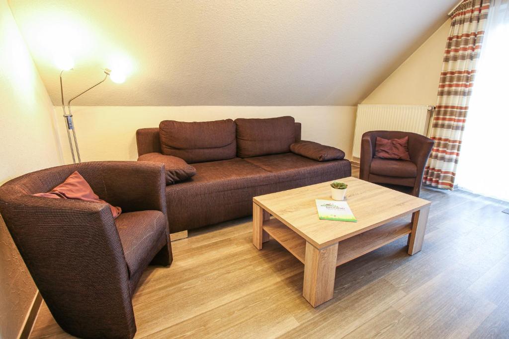 een woonkamer met een bank, twee stoelen en een tafel bij Familienhof Brüning - Stadtblick in Meppen