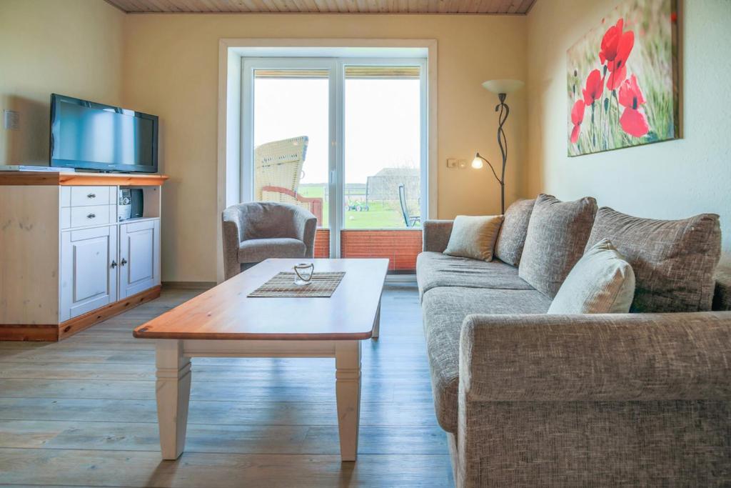 a living room with a couch and a coffee table at Ferienhof Büdlfarm - Haus in Fehmarn