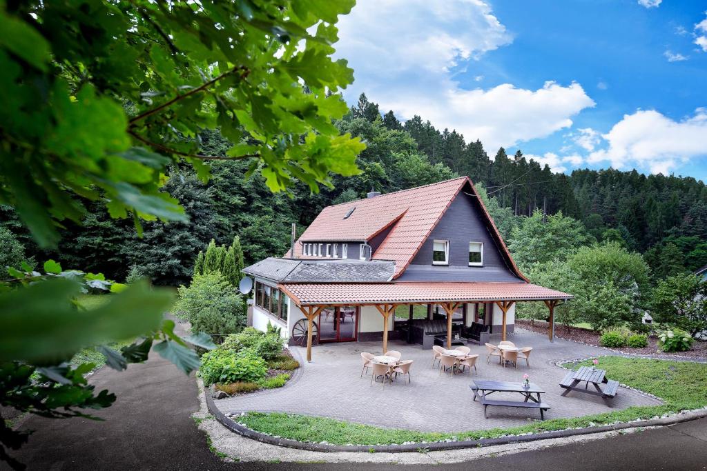 Elle offre une vue aérienne sur une maison dotée d'une terrasse. dans l'établissement Villa für 10 Personen im Westerwald mit Kino, Bar, Sauna und Whirlpool, à Schutzbach