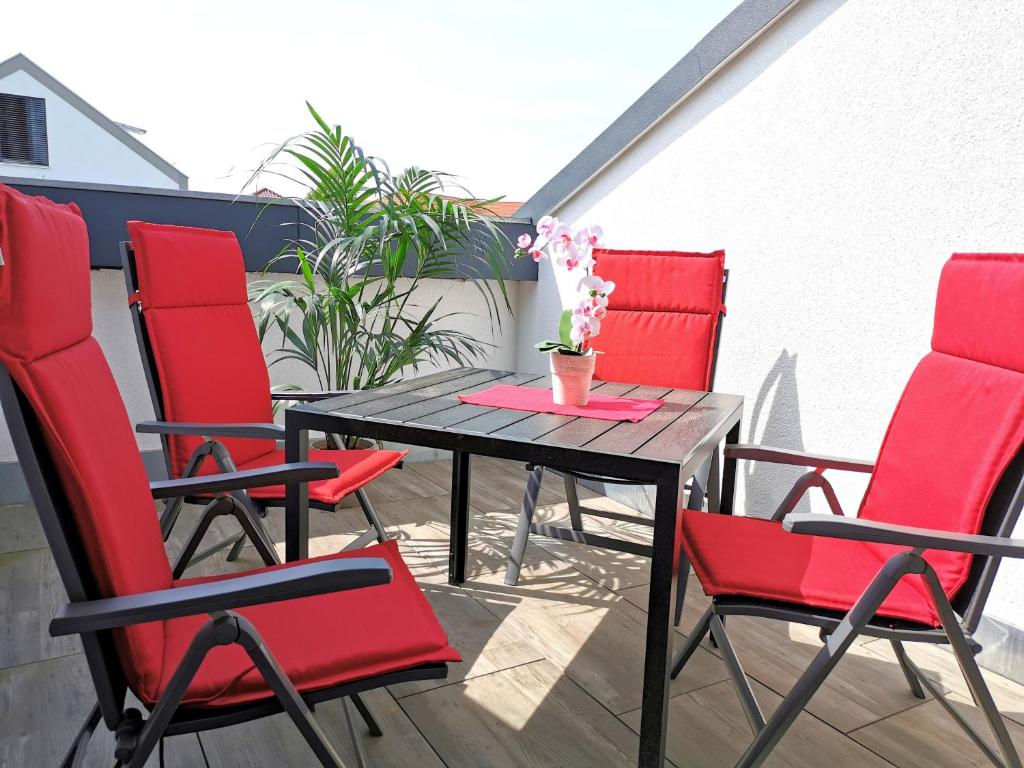 a table and four chairs on a balcony at Ferienwohnung Schöne Auszeit in Markkleeberg
