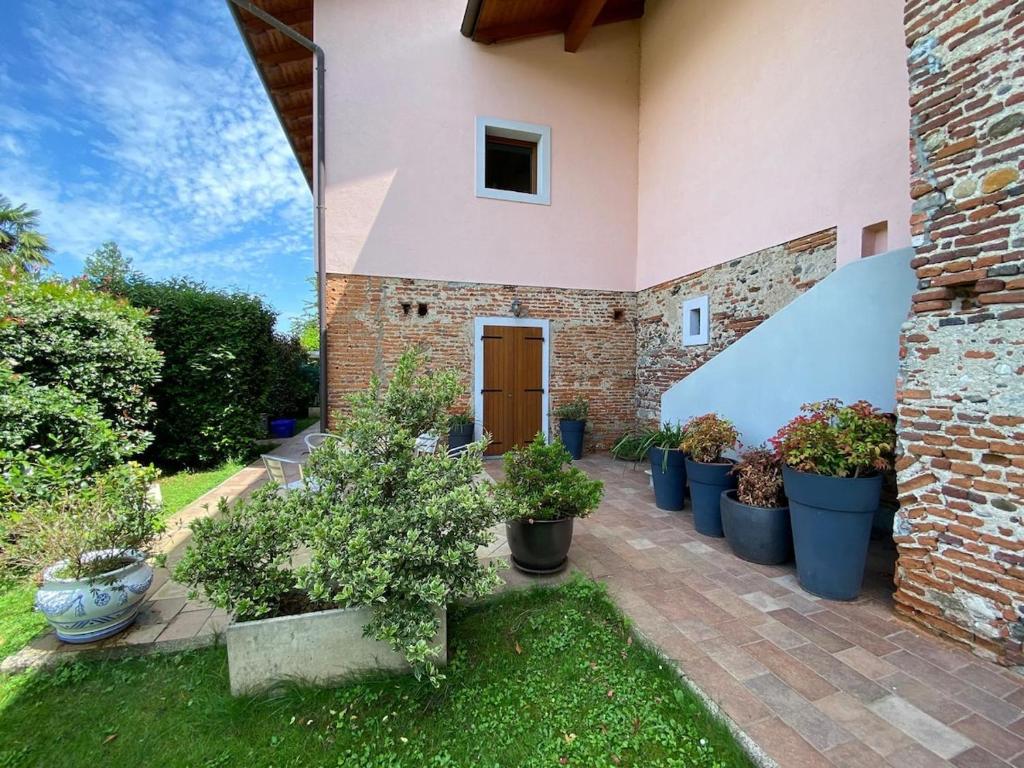 a courtyard of a house with a bunch of potted plants at Fuga nella Natura tra Laghi&Golf in Bogogno