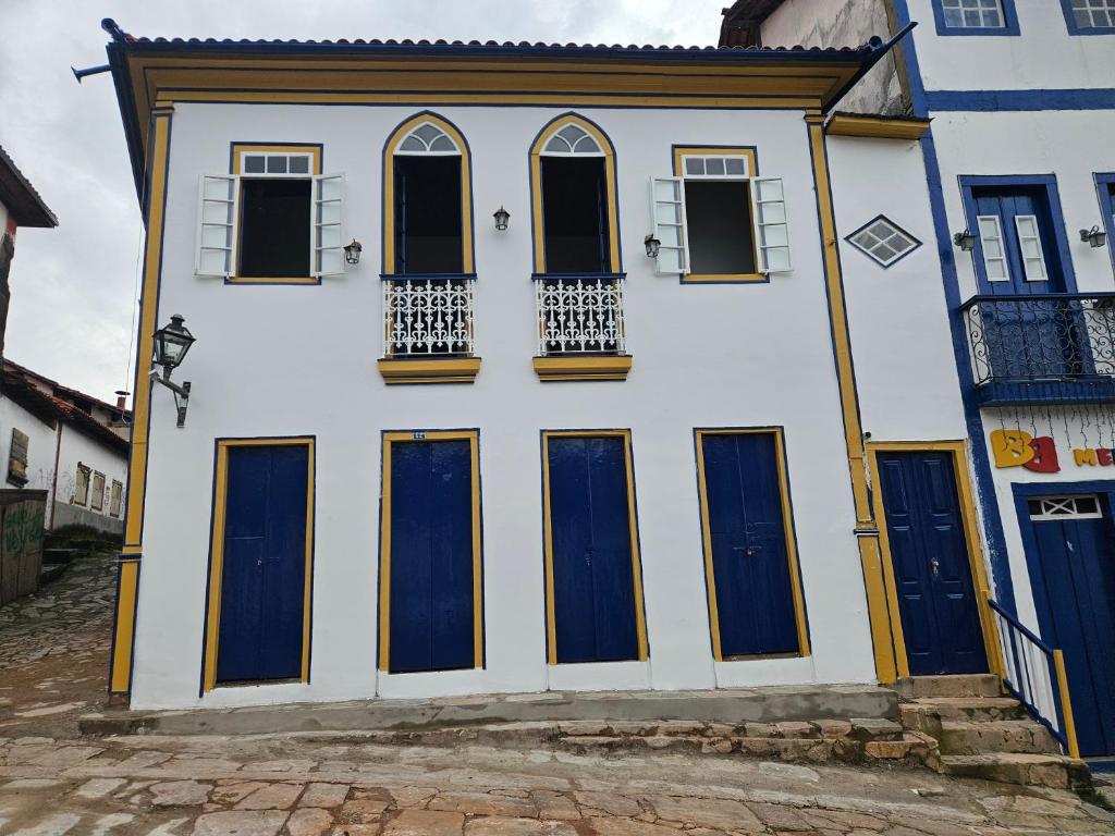 a white building with blue doors and windows at Vesperata Diamantina in Diamantina